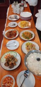 una mesa larga con platos de comida y arroz en Raflow Resort Raja Ampat en Tapokreng