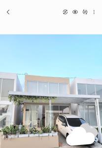 a white car parked in front of a house at BnB House Villa Jogja in Yogyakarta