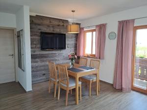 a dining room with a table and chairs and a tv at Asbichlerhof in Bad Endorf