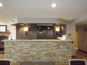 a bar in a restaurant with a stone wall at MICROTEL Inn and Suites - Ames in Ames