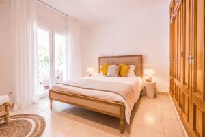 ein Schlafzimmer mit einem großen Bett mit gelben Kissen in der Unterkunft Casa Oleander in Balcon del Mar + 28 Fotos