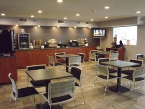 a restaurant with tables and chairs and a counter at MICROTEL Inn and Suites - Ames in Ames