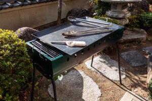 ein Grill mit Grillzange und einer Grillzange obendrauf in der Unterkunft -玉島茶室-歴史を感じる和の空間Tea Room ペット同伴 BBQ可 in Nagao