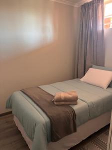 Un dormitorio con una cama con una toalla. en Kay’s place, en Pretoria