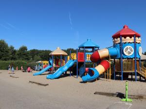 un parque infantil con tobogán y equipo de juegos en la playa en Recreatiepark Duinhoeve 5, en Udenhout