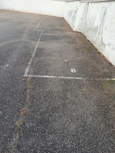um parque de estacionamento vazio ao lado de uma parede branca em Maisonnette abj em Anneyron