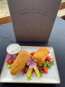 a plate of food with two fishnets and a salad at Lolini bungalovi in Novi Sad