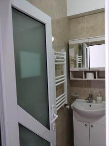 bagno con lavandino e porta a vetri di Casa Mary a Eforie Nord
