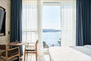 Postel nebo postele na pokoji v ubytování Yeosu Calacatta Hotel & Resort
