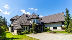 una casa con techo de gambrel en Rezydencja Marjo z basenem, en Kościelisko