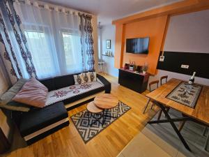 a living room with a couch and a table at Apartament Bystra Woda 28 z garażem in Zakopane