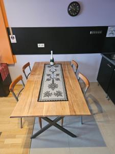 una mesa de madera con sillas y un jarrón en la parte superior en Apartament Bystra Woda 28 z garażem, en Zakopane