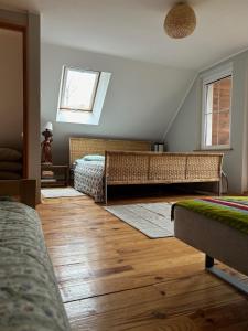 1 dormitorio con 2 camas, suelo de madera y ventana en Domek nad Wkrą en Popielżyn Górny