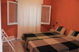 a bedroom with a checkered bed and two windows at Agradable apartamento en Playa La Pineda (Tarragona) in La Pineda