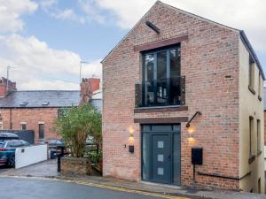 uma casa de tijolos com uma porta preta numa rua em 3 Bed in Harrogate 86490 em Harrogate