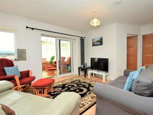 a living room with a couch and a tv at 4 Bed in Ogmore-By-Sea 87141 in Saint Brides Major
