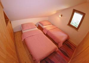 2 camas en una habitación pequeña con ventana en Domcek v strani, en Mýto pod Ďumbierom