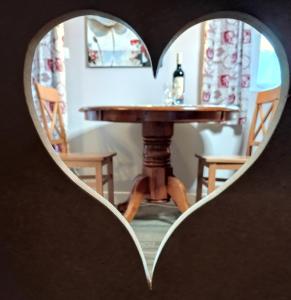 uma mesa numa janela em forma de coração com uma mesa ao fundo em Le Stadl Vosges em Jussarupt