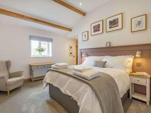a bedroom with a large bed and a chair at 3 Bed in Shaftesbury 87724 in Sedghill