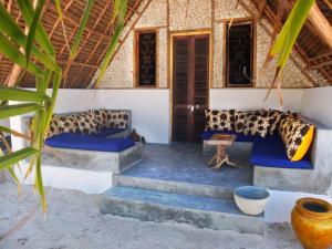 une chambre avec des canapés bleus et des escaliers dans une maison dans l'établissement Nur Beach Hotel, à Jambiani
