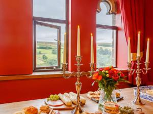 a table topped with plates of food and candles at 5 Bed in Haworth 88390 in Oxenhope