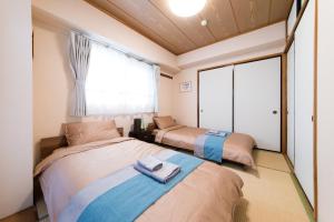 2 camas en una habitación con ventana en nestay apartment tokyo akihabara en Tokio