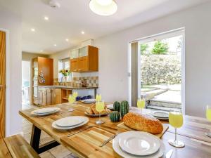 uma cozinha com uma mesa de madeira com pratos e copos de vinho em 5 Bed in Crich 88486 em Crich