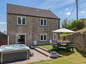 a house with a pool and a table and an umbrella at 5 Bed in Crich 88486 in Crich