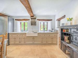 a large kitchen with wooden cabinets and a sink at 5 Bed in Kendal 88095 in Skelsmergh