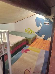 um quarto com duas camas e uma parede com monstros pintados nele em Gite du p'tit fermier em Cunlhat