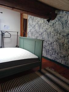 um quarto com uma cama e uma parede com um papel de parede em Gite du p'tit fermier em Cunlhat