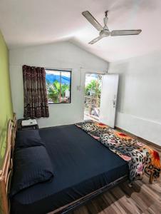 sypialnia z dużym łóżkiem i wentylatorem sufitowym w obiekcie Nature of Arambol w mieście Arambol
