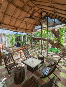 eine Terrasse mit Stühlen, einem Tisch und einem Sonnenschirm in der Unterkunft Nature of Arambol in Arambol