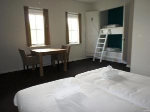 ウェーメルディンゲにあるSpacious holiday home at 50 m. from the Oosterscheldeのベッドルーム1室(ベッド1台、テーブル、はしご付)
