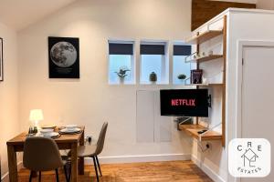 a dining room with a table and a tv at The Little House in Maidstone