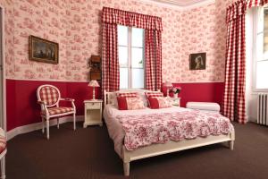 a pink bedroom with a bed and a chair at Chateau Carbonneau in Pessac-sur-Dordogne