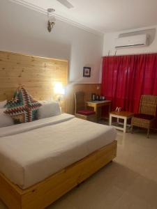 a bedroom with a large bed and a red curtain at hotel saina inn in Dehradun