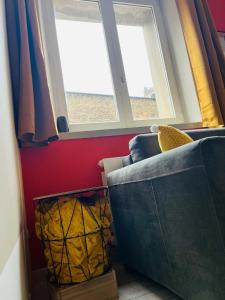 een woonkamer met een bank en twee ramen bij Bienvenue l'Opale Boulogne in Boulogne-sur-Mer +23 foto's