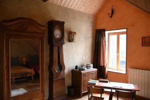 a room with a grandfather clock and a table at Le Deyran in Égliseneuve-dʼEntraigues +26 photos
