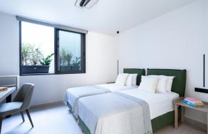 a bedroom with two beds and a desk and windows at Torretta - Harmonia in Lygia +16 photos