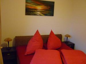 オストゼーバート・カールスハーゲンにあるFewo Wiesenblick_MEYHの赤いソファ(リビングルーム内の赤い枕付)