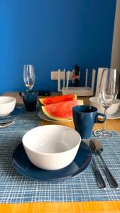 una mesa con un tazón, platos y copas de vino en HuaHin DusitD2 Residences, apartments near beach en Hua Hin