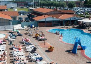 uma vista superior para uma piscina com pessoas sentadas em espreguiçadeiras em Kapelludden Camping & Stugor em Borgholm