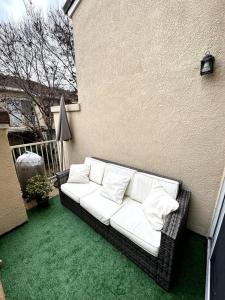 a white couch sitting on the side of a building at Bohemian Bliss 10 Min from DT SJ in San Jose