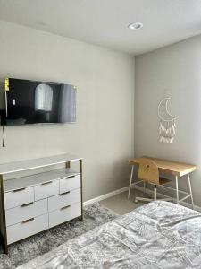 a bedroom with a bed and a desk and a television at Bohemian Bliss 10 Min from DT SJ in San Jose
