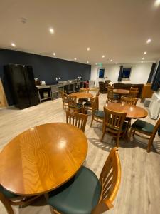 a restaurant with wooden tables and chairs and a kitchen at luxury pod with hot tub in Clodock