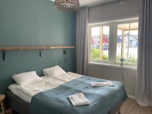 1 dormitorio con 1 cama con manta azul y ventana en Villa Sharevik, 