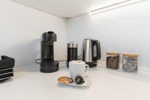 a coffee maker and a cup of coffee and cookies on a counter at Bodensee-Suite IStayUnixI Seenähe-HomeKino-Wintergarten in Öhningen