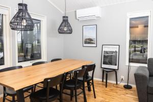 a dining room with a wooden table and chairs at Kapelludden Camping & Stugor in Borgholm