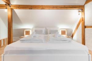a large white bed in a room with an attic at Bodensee-Suite IStayUnixI Seenähe-HomeKino-Wintergarten in Öhningen